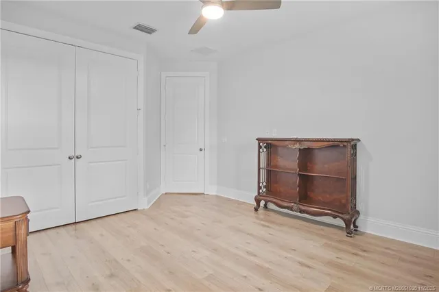 a view of room with hardwood floor and ceiling fan