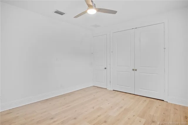 a room with a chair and a ceiling fan