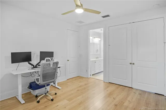 a view of a workspace with furniture and a window