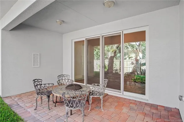 a view of backyard with table and chairs and large trees