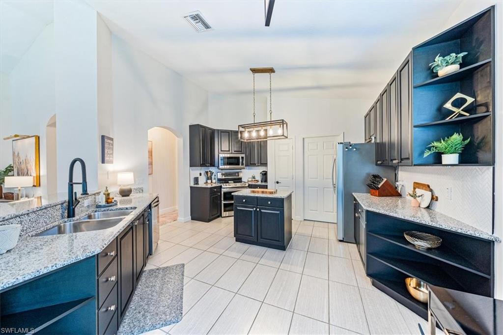 20280 Burnside Place, Unit 1202 Estero, FL 33928 - Photo 11 of 42 a kitchen with stainless steel appliances granite countertop a sink stove and refrigerator