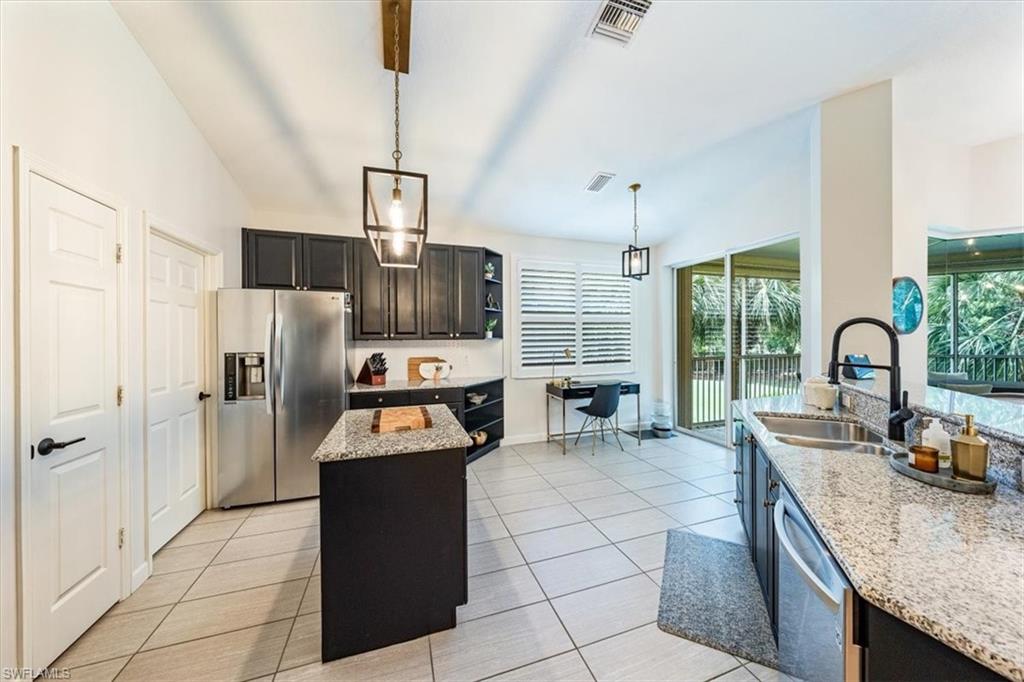 20280 Burnside Place, Unit 1202 Estero, FL 33928 - Photo 12 of 42 a kitchen with granite countertop a refrigerator and a sink