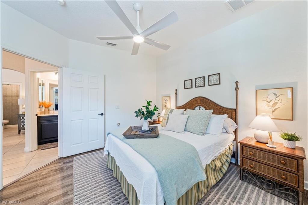 20280 Burnside Place, Unit 1202 Estero, FL 33928 - Photo 15 of 42 a bedroom with a bed and wooden floor