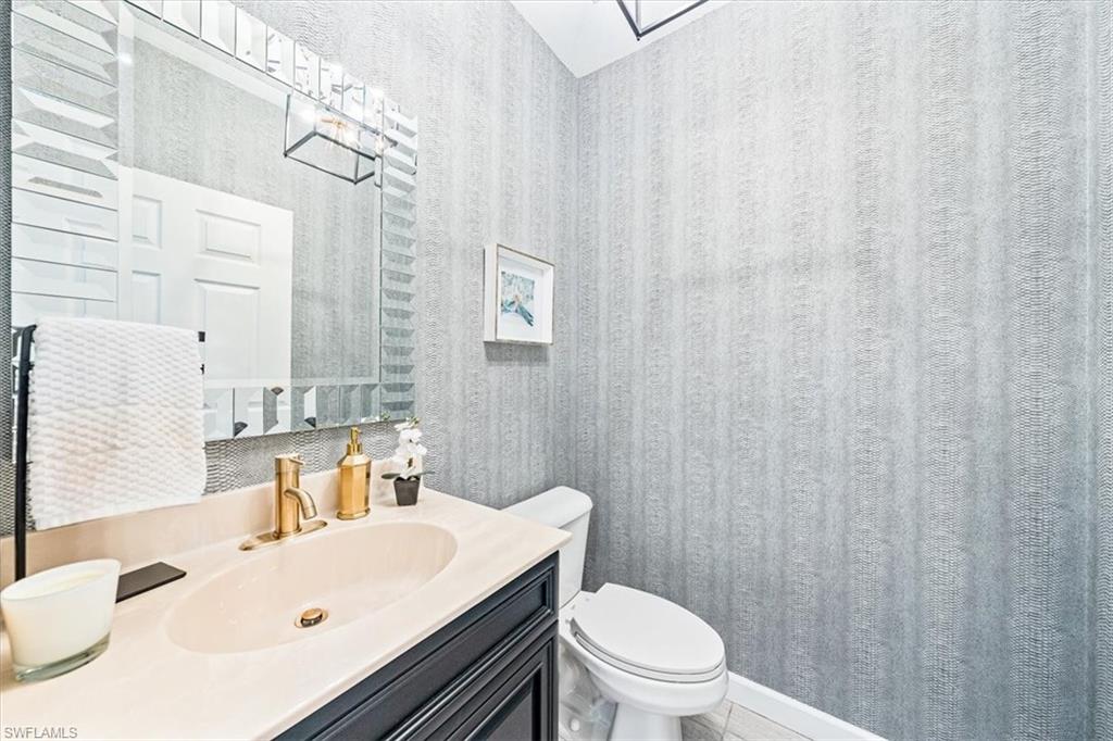 20280 Burnside Place, Unit 1202 Estero, FL 33928 - Photo 18 of 42 a bathroom with a sink a toilet and shower curtain