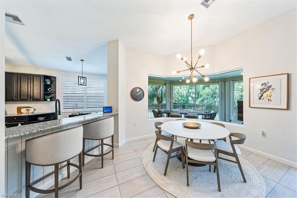 20280 Burnside Place, Unit 1202 Estero, FL 33928 - Photo 19 of 42 a dining room with furniture a chandelier and window