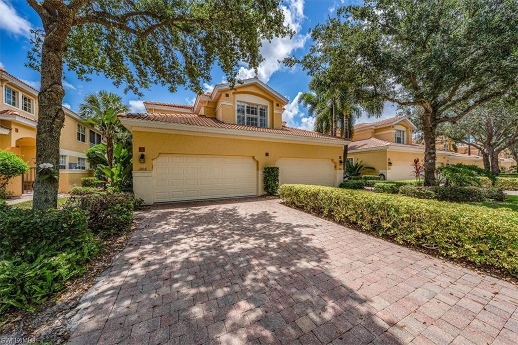 20280 Burnside Place, Unit 1202 Estero, FL 33928 - Photo 3 of 42 a front view of a house with a yard and garage