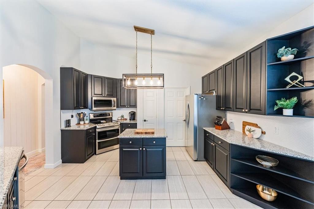 20280 Burnside Place, Unit 1202 Estero, FL 33928 - Photo 32 of 42 a kitchen with stainless steel appliances a stove refrigerator sink and microwave