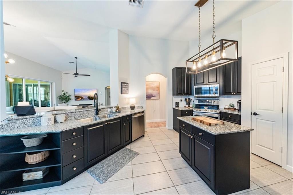 20280 Burnside Place, Unit 1202 Estero, FL 33928 - Photo 34 of 42 a kitchen with stainless steel appliances granite countertop a stove and a sink