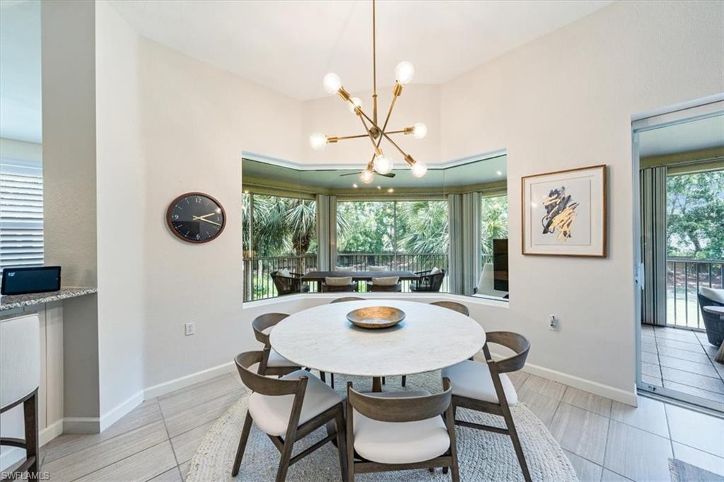 20280 Burnside Place, Unit 1202 Estero, FL 33928 - Photo 35 of 42 a view of a dining room with furniture a chandelier and wooden floor