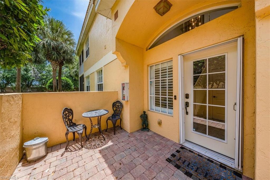 20280 Burnside Place, Unit 1202 Estero, FL 33928 - Photo 6 of 42 a view of a patio with table and chairs and wooden floor