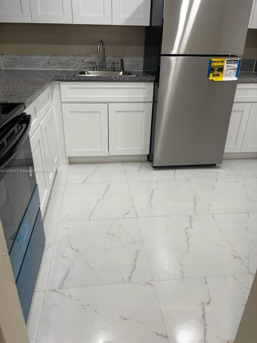 Ojus Miami, FL 33179 - Photo 5 of 15 a kitchen with stainless steel appliances a stove a refrigerator a sink a counter space and cabinets