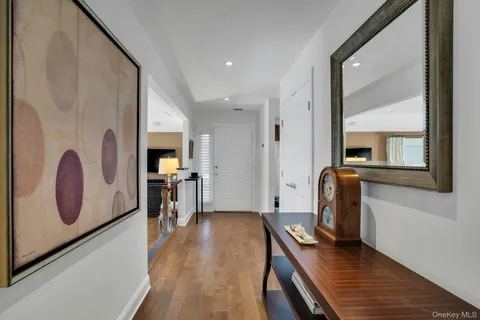 a view of a hallway with wooden floor windows and a kitchen