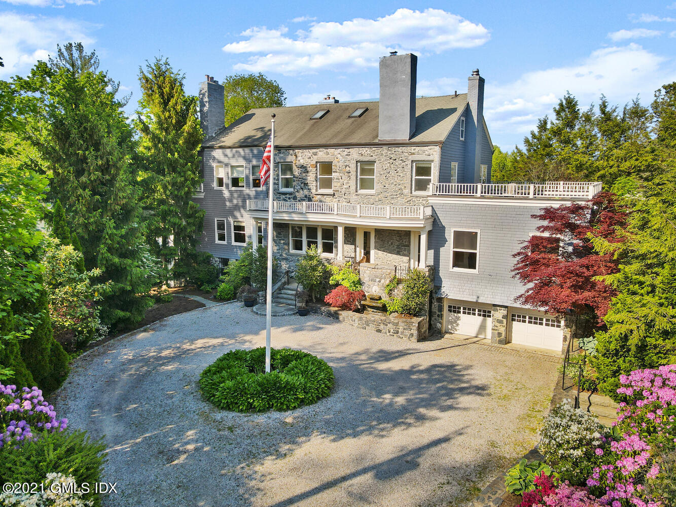 a view of a white house with a yard and garden