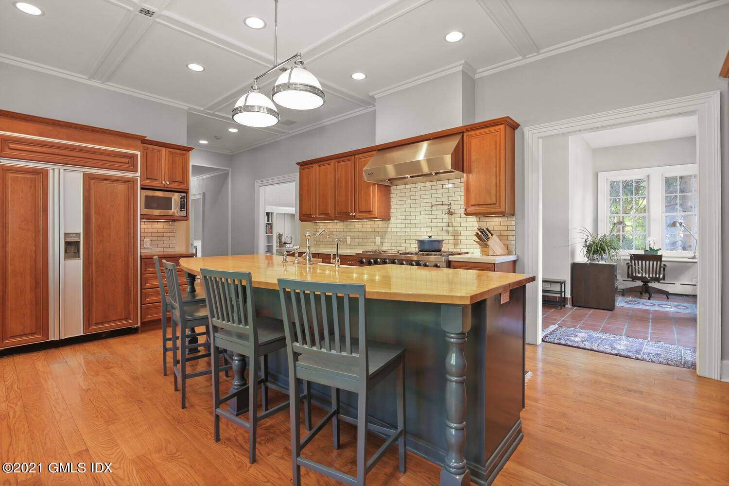 1 North Street Greenwich, CT 06830 - Photo 18 of 36 a kitchen with stainless steel appliances granite countertop a stove a refrigerator a kitchen island a dining table and chairs with wooden floor