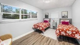 a bedroom with two beds and a large window