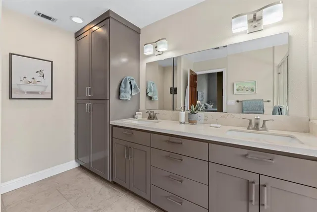a bathroom with a double vanity sink and a mirror
