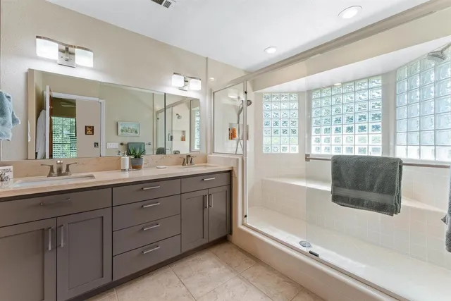 a spacious bathroom with a tub sink shower and mirror