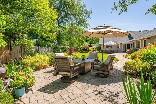 a view of a patio with table and chairs under an umbrella