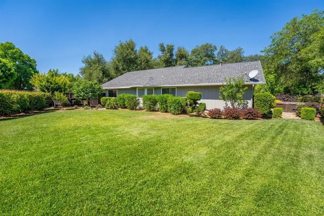 a front view of a house with a yard and trees