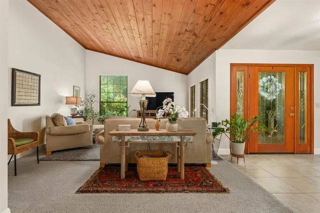a living room with furniture a large window and potted plants