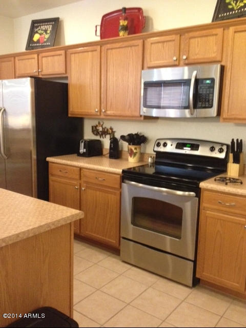 1250 South Rialto, Unit 62 Mesa, AZ 85209 - Photo 8 of 24 a kitchen with stainless steel appliances a stove microwave and cabinets