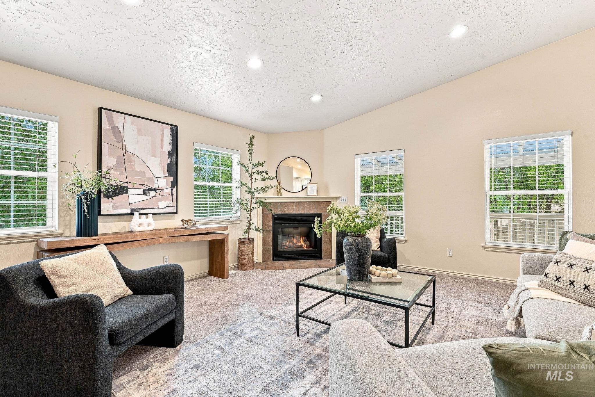2442 West Hill Road Boise, ID 83702 - Photo 7 of 48 Living area featuring a corner fireplace with a tile surround and wood mantel, multiple windows, recessed lighting, and vaulted ceilings