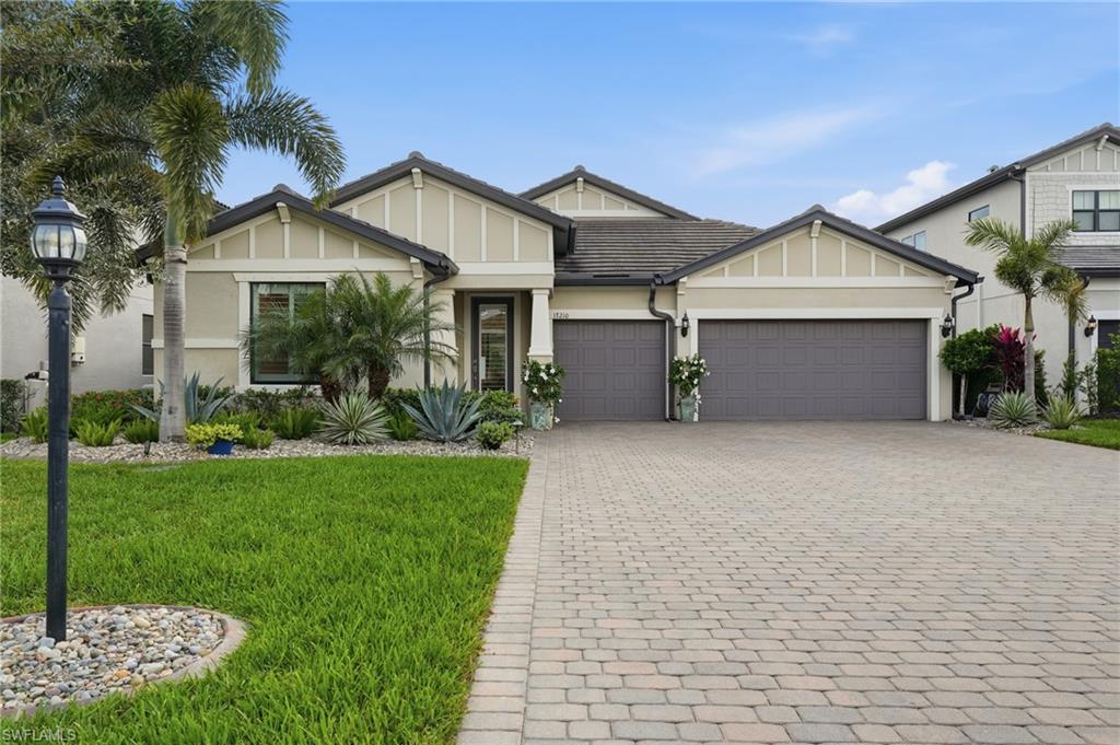 17210 Ashcomb Way Estero, FL 33928 - Photo 2 of 47 a front view of a house with a garden and yard