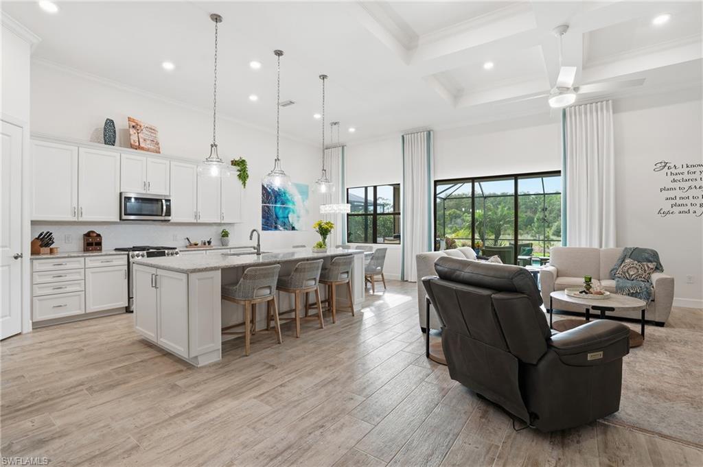 17210 Ashcomb Way Estero, FL 33928 - Photo 5 of 47 a large kitchen with cabinets wooden floor and a view of living room