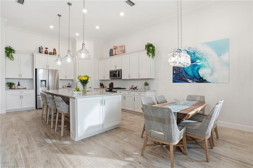 17210 Ashcomb Way Estero, FL 33928 - Photo 7 of 47 a dining room filled chandelier and kitchen view