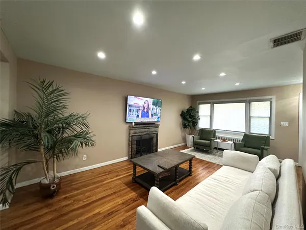 a living room with furniture floor to ceiling window and wooden floor