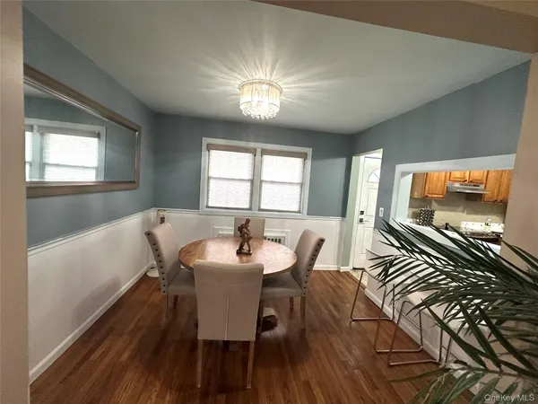 a view of a dining room with furniture a chandelier and wooden floor