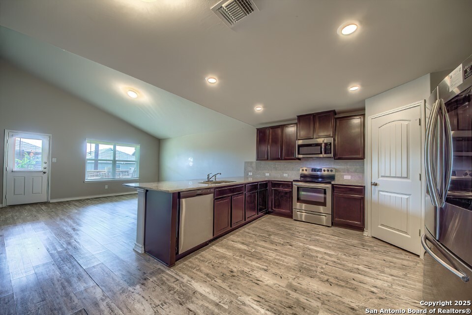 7006 Quantum Loop San Antonio, TX 78252 - Photo 7 of 37 a kitchen with stainless steel appliances granite countertop a refrigerator stove top oven and sink