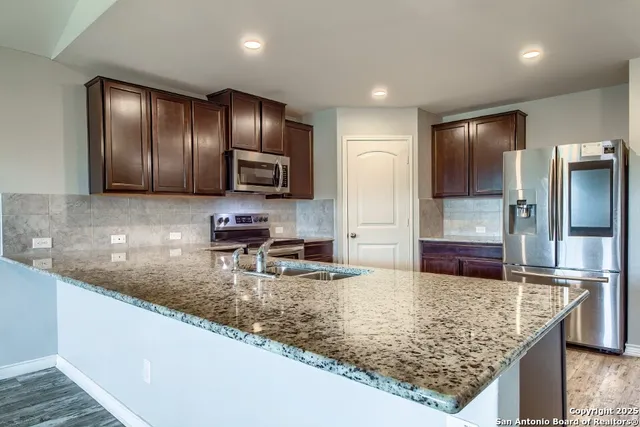 a kitchen with stainless steel appliances granite countertop granite counter tops and wooden cabinets