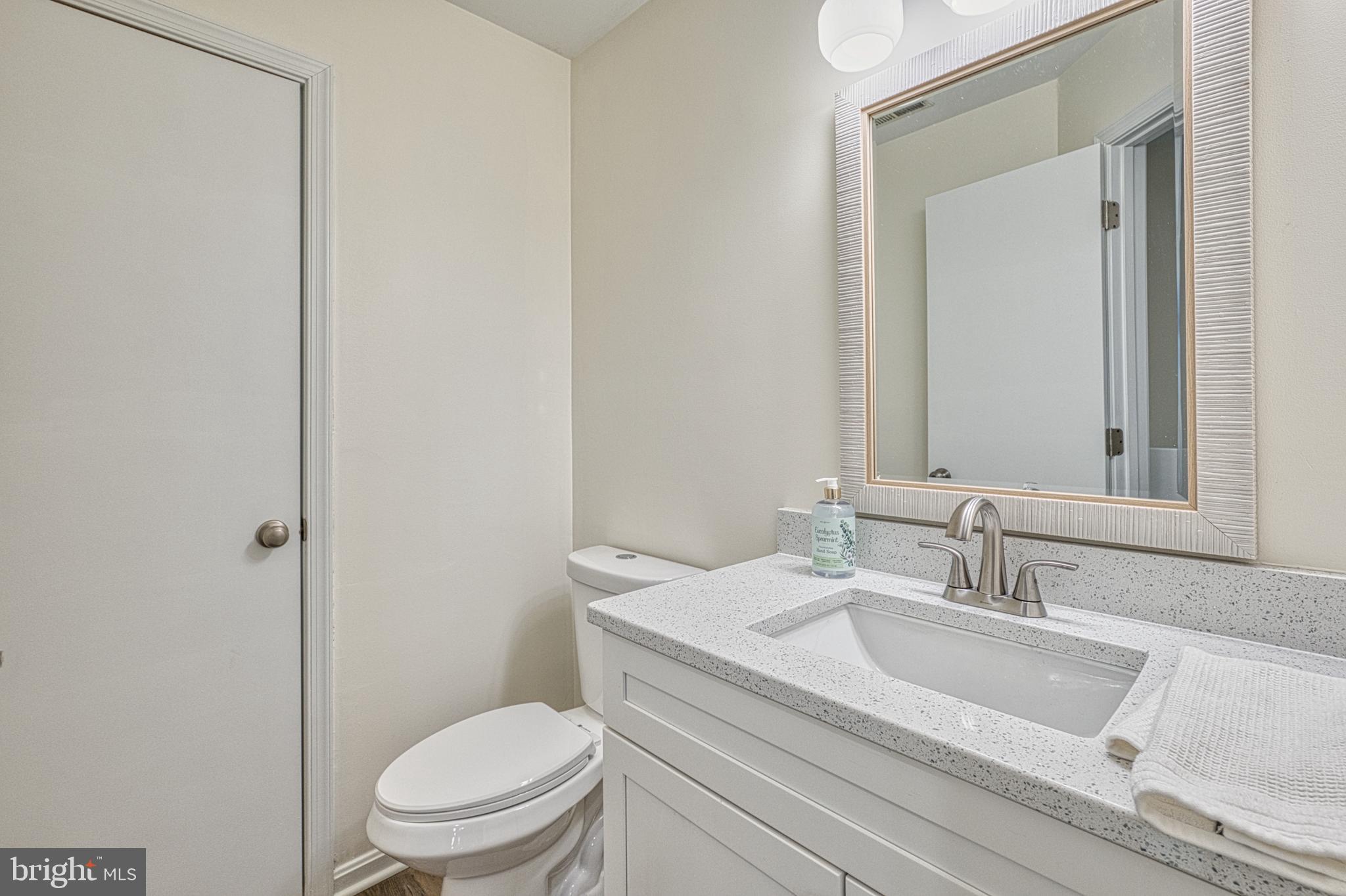 34 Queen Anne Way Chester, MD 21619 - Photo 12 of 52 a bathroom with a granite countertop toilet a sink and a mirror