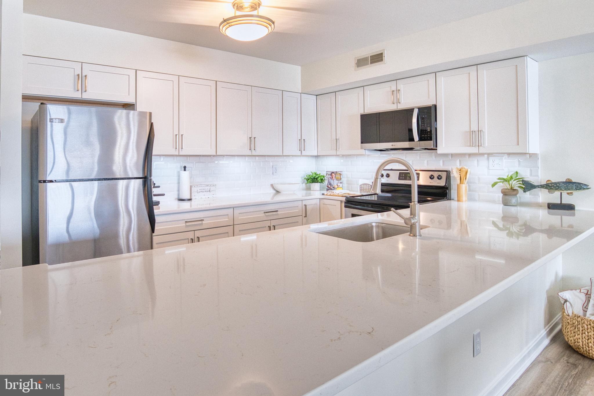 34 Queen Anne Way Chester, MD 21619 - Photo 2 of 52 a kitchen with stainless steel appliances granite countertop a sink a refrigerator a microwave a stove and white cabinets