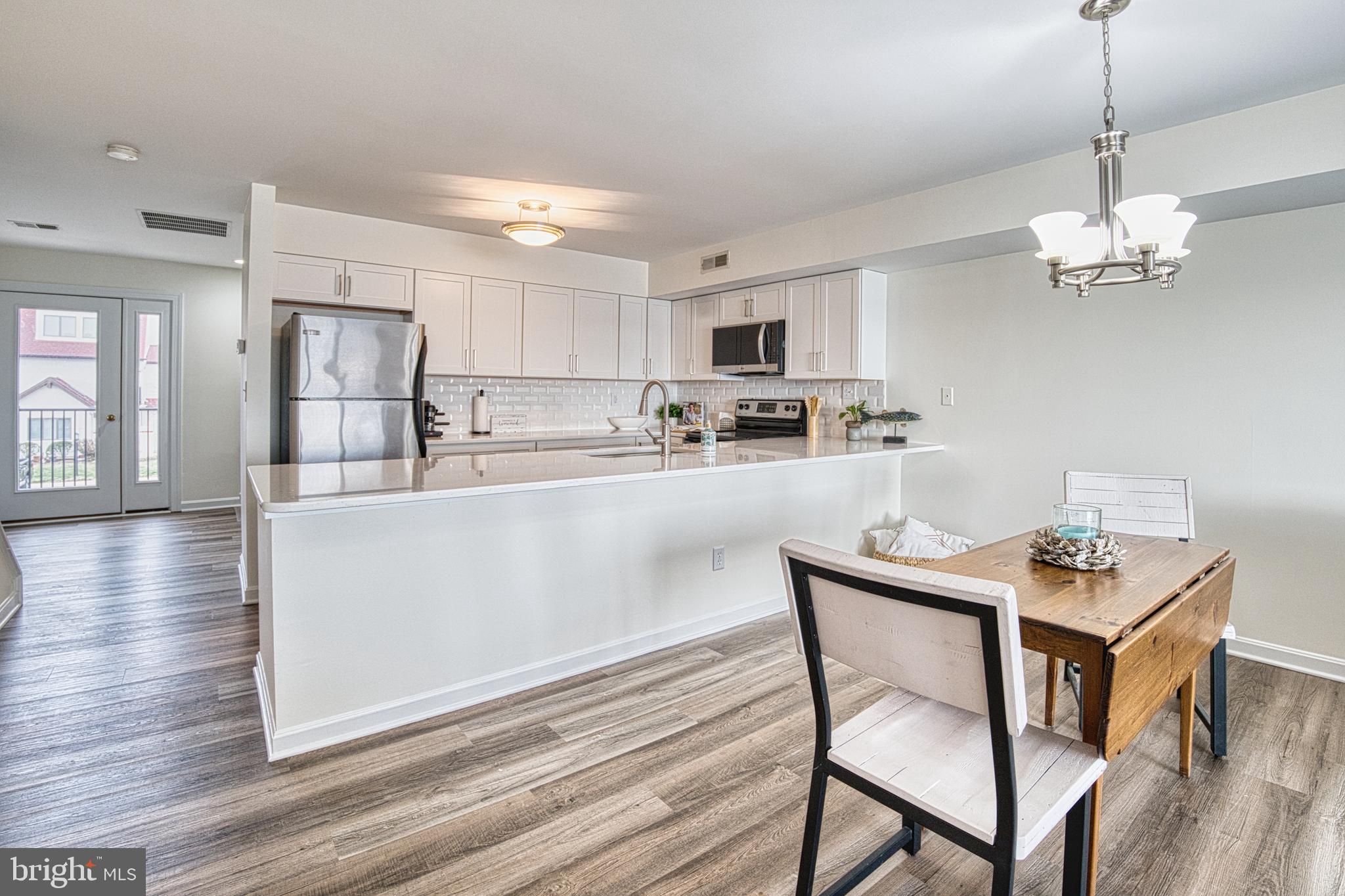 34 Queen Anne Way Chester, MD 21619 - Photo 6 of 52 a kitchen with kitchen island granite countertop stainless steel appliances a dining table chairs and a refrigerator