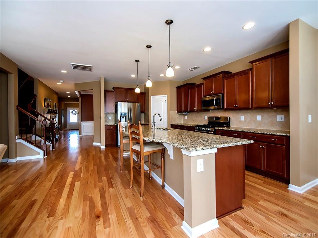 4242 Perth Road Indian Land, SC 29707 - Photo 11 of 24 a large kitchen with stainless steel appliances granite countertop a stove a sink dishwasher and a refrigerator with wooden floor