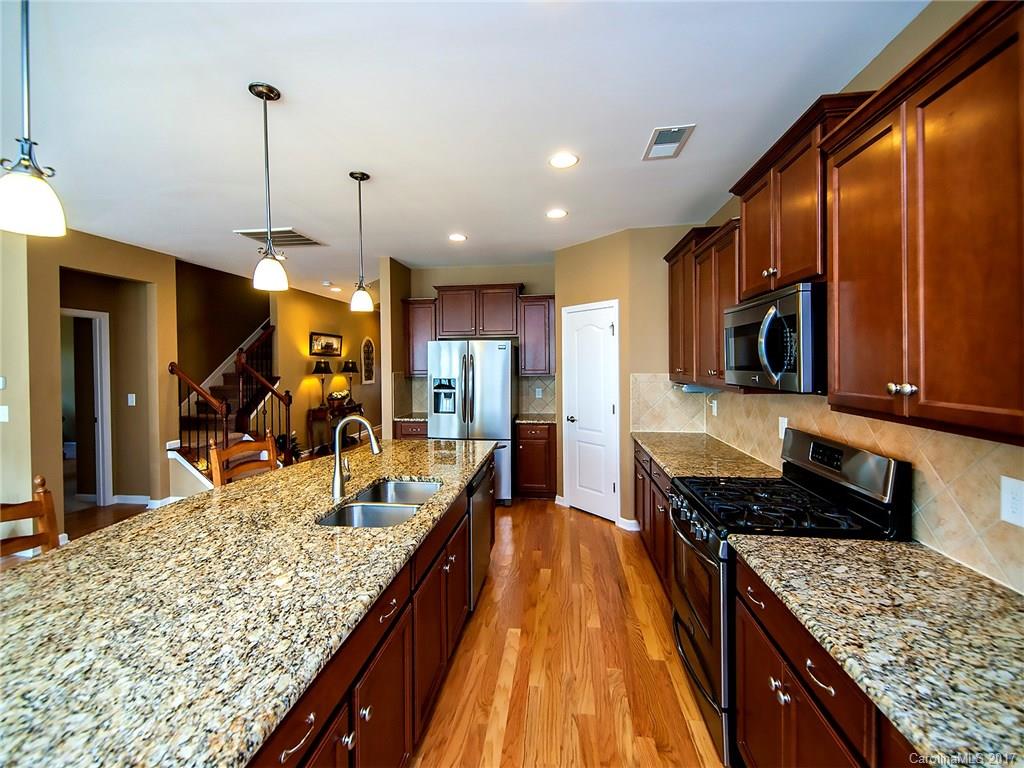 4242 Perth Road Indian Land, SC 29707 - Photo 12 of 24 a kitchen with stainless steel appliances kitchen island granite countertop wooden cabinets and granite counter tops