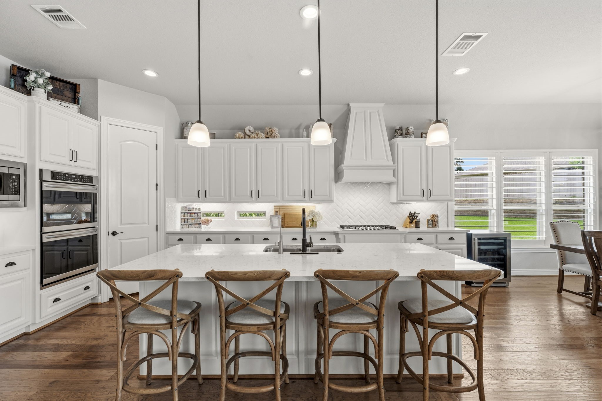14012 Beartooth Bend Trail Conroe, TX 77384 - Photo 14 of 50 The kitchen's centerpiece is a stunning oversized island featuring abundant prep space, breakfast seating, and designer pendant lighting. A deep double-basin stainless steel sink with a pull-out sprayer faucet makes meal prep and cleanup effortless. (Please exclude reverse osmosis faucet and system)