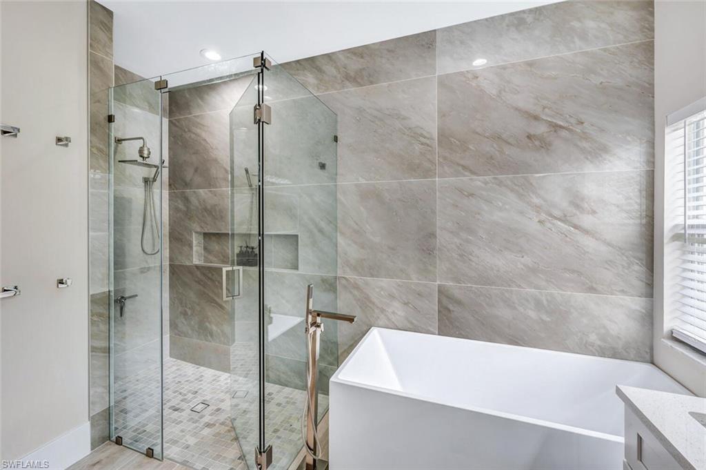 8260 Laurel Lakes Boulevard Naples, FL 34119 - Photo 23 of 41 a bathroom with a bathtub and a shower