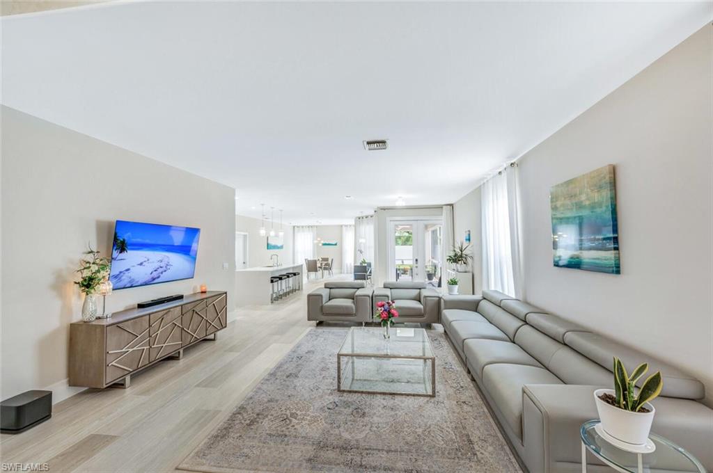 8260 Laurel Lakes Boulevard Naples, FL 34119 - Photo 5 of 41 a living room with furniture and a flat screen tv