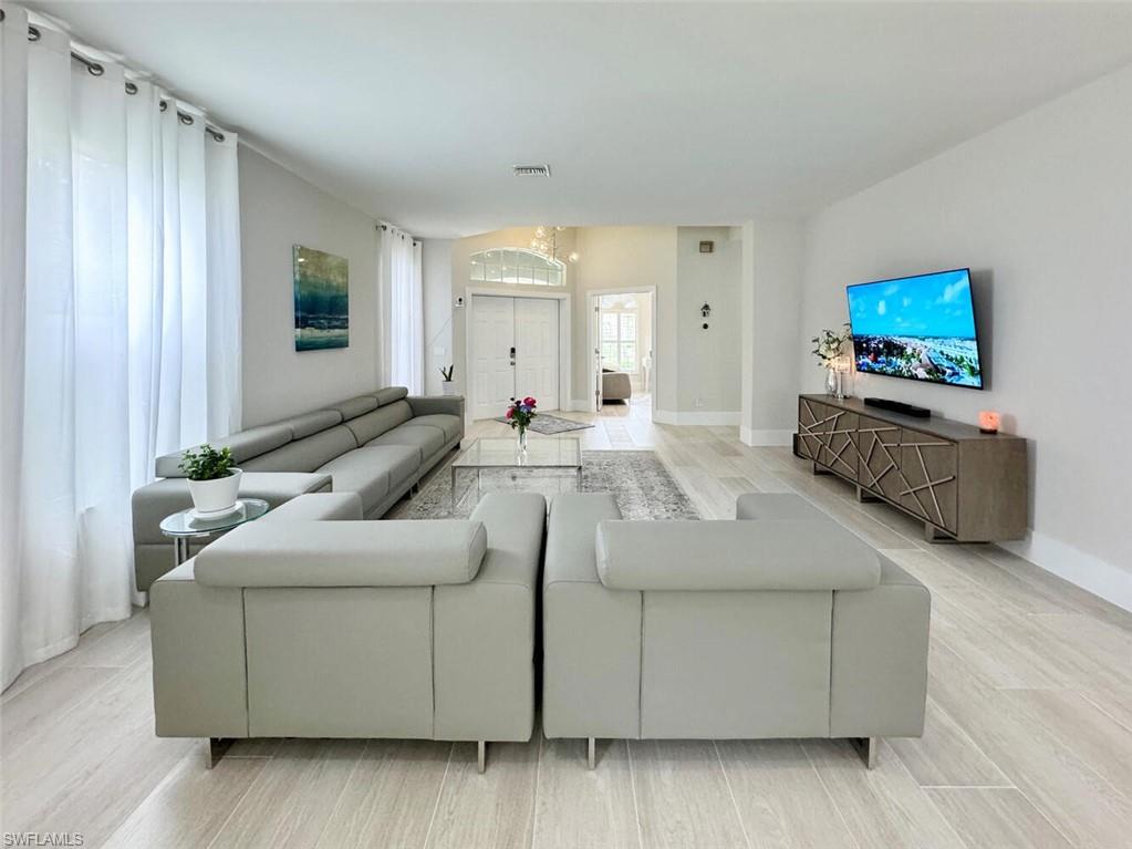 8260 Laurel Lakes Boulevard Naples, FL 34119 - Photo 6 of 41 a living room with furniture and a flat screen tv