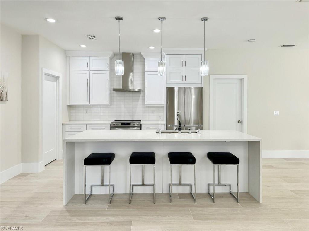 8260 Laurel Lakes Boulevard Naples, FL 34119 - Photo 10 of 41 a kitchen with stainless steel appliances kitchen island a sink and a refrigerator
