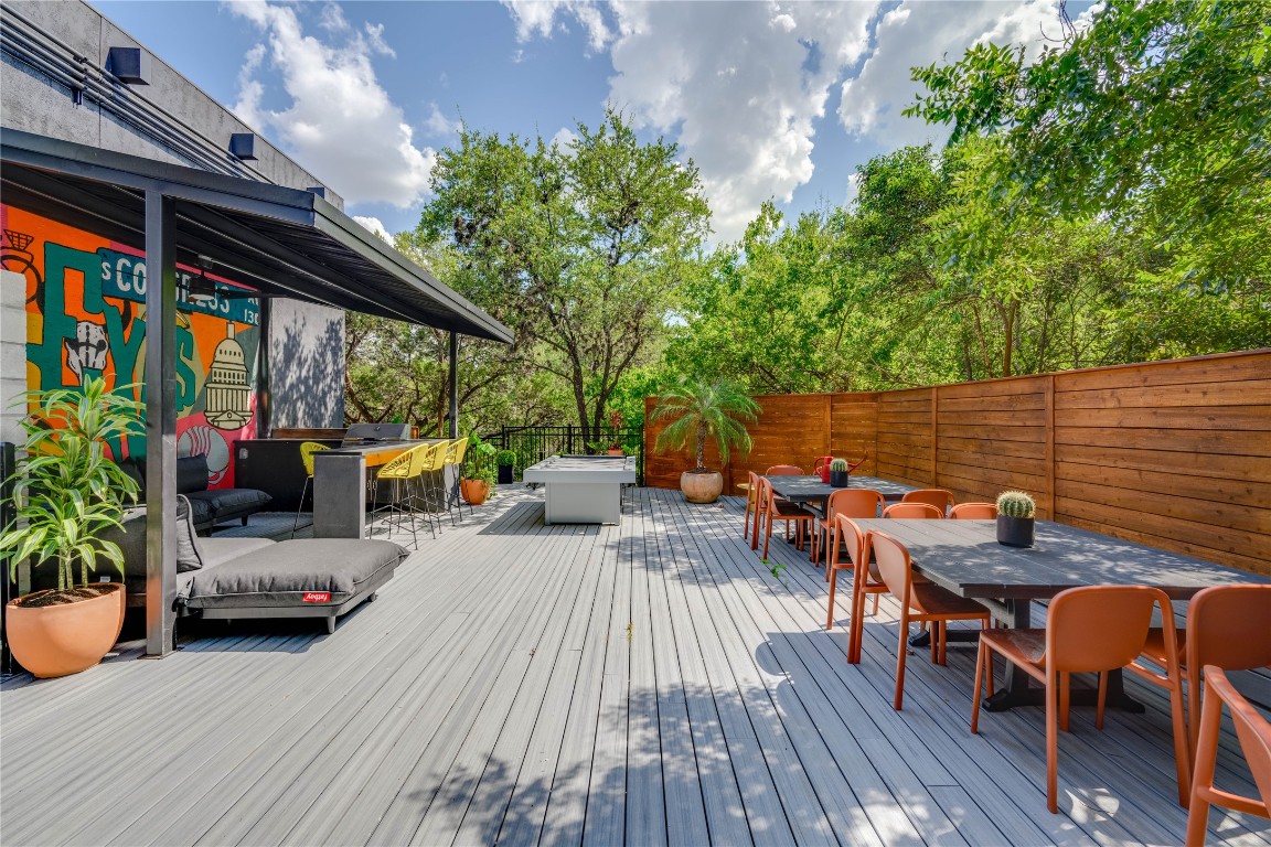 513 Pecan Grove Road, Unit 102 Austin, TX 78704 - Photo 14 of 15 a view of deck with table and chairs potted plants with wooden floor and fence