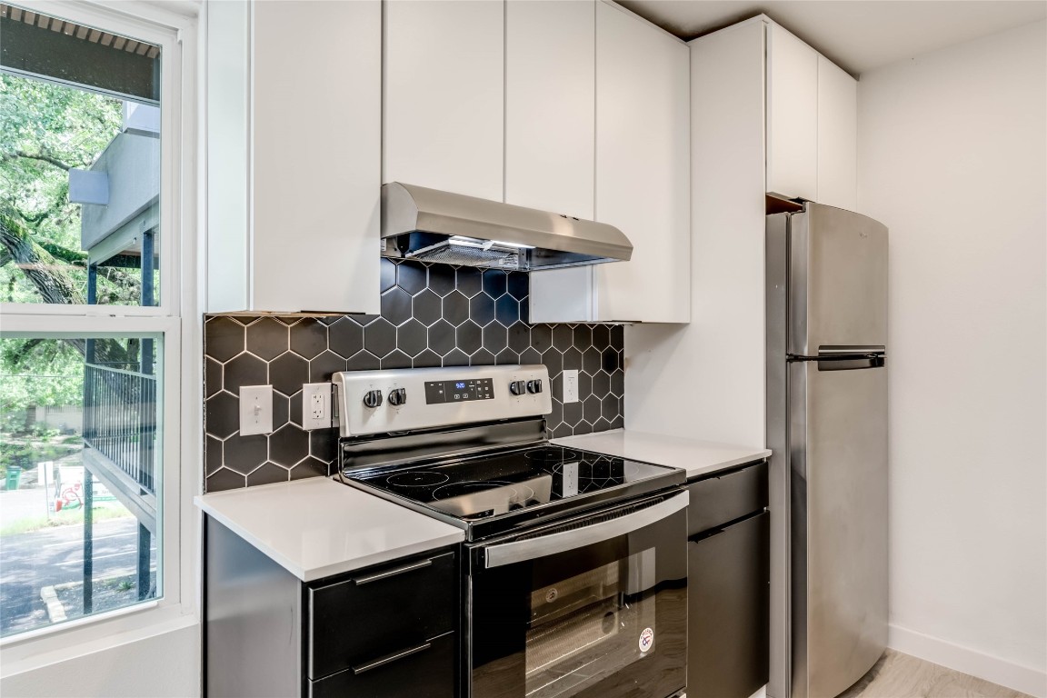 513 Pecan Grove Road, Unit 102 Austin, TX 78704 - Photo 4 of 15 a kitchen with a stove and a refrigerator