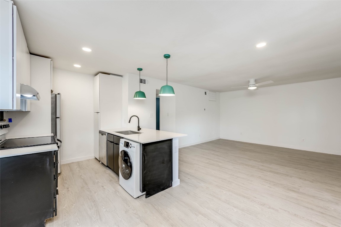 513 Pecan Grove Road, Unit 102 Austin, TX 78704 - Photo 5 of 15 a kitchen with stainless steel appliances a stove a sink and a refrigerator