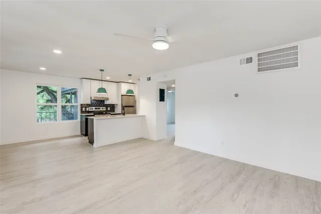 a view of kitchen with wooden floor and electronic appliances