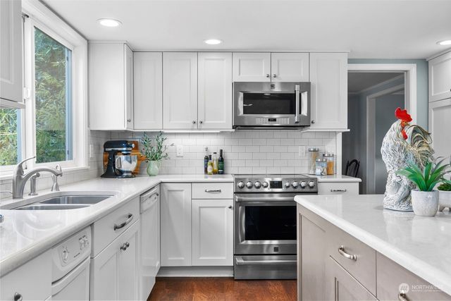 a kitchen with white cabinets and a stove top oven