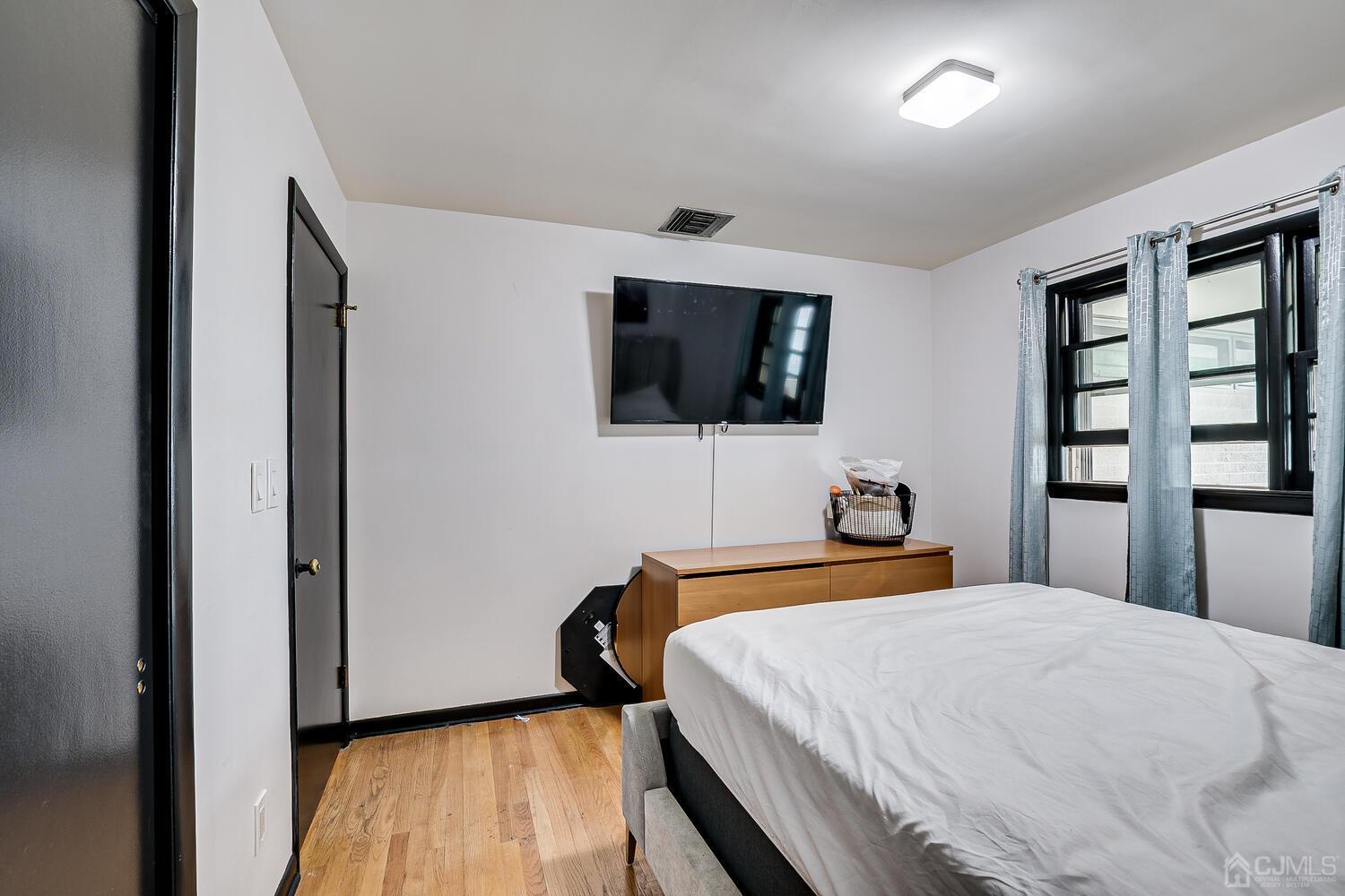 319 Chain O' Hills Road Colonia, NJ 07067 - Photo 20 of 37 a bedroom with a bed and a flat screen tv