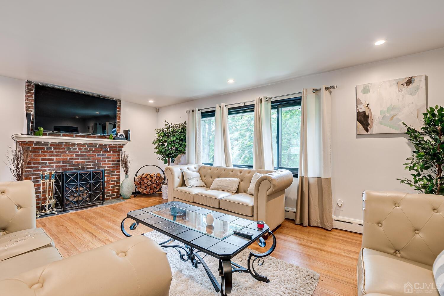 319 Chain O' Hills Road Colonia, NJ 07067 - Photo 7 of 37 a living room with furniture a fireplace and a flat screen tv